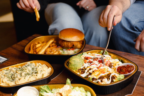 Dinner table with various food items including a burger, fries, and salad.