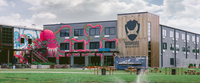 Modern building with colorful graphics and 'Doughouse' branding on a cloudy day.