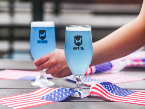 Two glasses of BrewDog beer on a table with American flags.