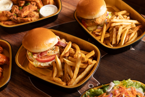 Plated burgers with fries on a wooden table